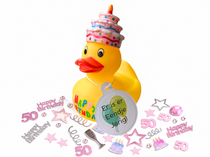 Gele verjaardagsbadeend met taart en kaars op het hoofd, hanglabel ‘Er is er Eendje Jarig!’ en roze en zilveren confetti voor 50 jaar.