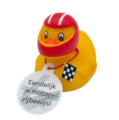 Gele badeend met rode motorhelm, zwart-witte racevlag en een hangtag met de tekst ‘Eendelijk je motorrijbewijs!’.