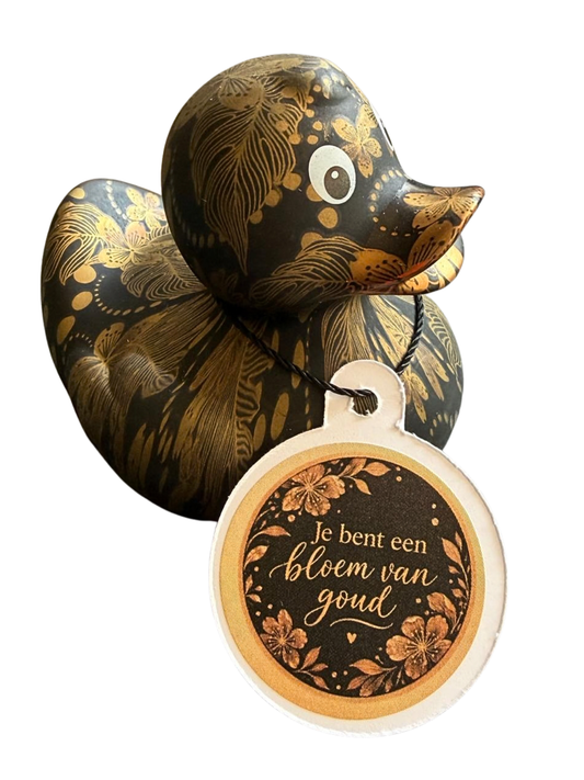 Zwarte badeend met goudkleurig bloemen- en verenpatroon en een hangtag met de tekst ‘Je bent een bloem van goud’.