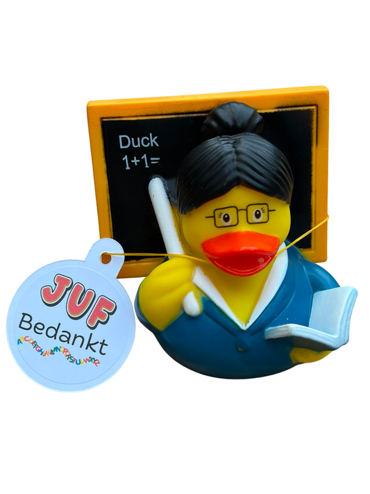 Gele jufbadeend met zwarte haarknot, bril, blauwe kleding, boek en aanwijsstok voor een schoolbord, met een hangtag ‘JUF Bedankt’.
