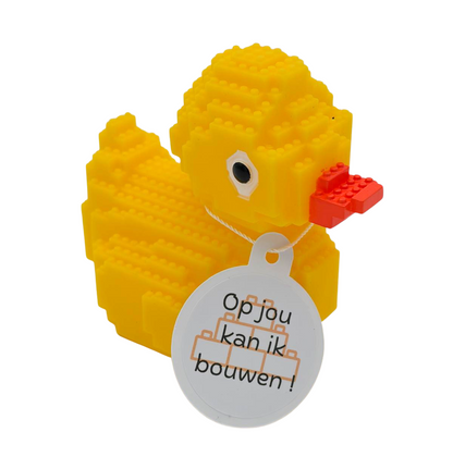 Gele badeend in bouwsteentjesstijl met oranje snavel en een witte hangtag met bouwblokjes en de tekst ‘Op jou kan ik bouwen!’.