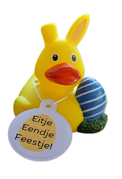 Gele paas-badeend met konijnenoren en een blauw gestreept paasei, met een witte hangtag met de tekst ‘Eitje Eendje Feestje!’.