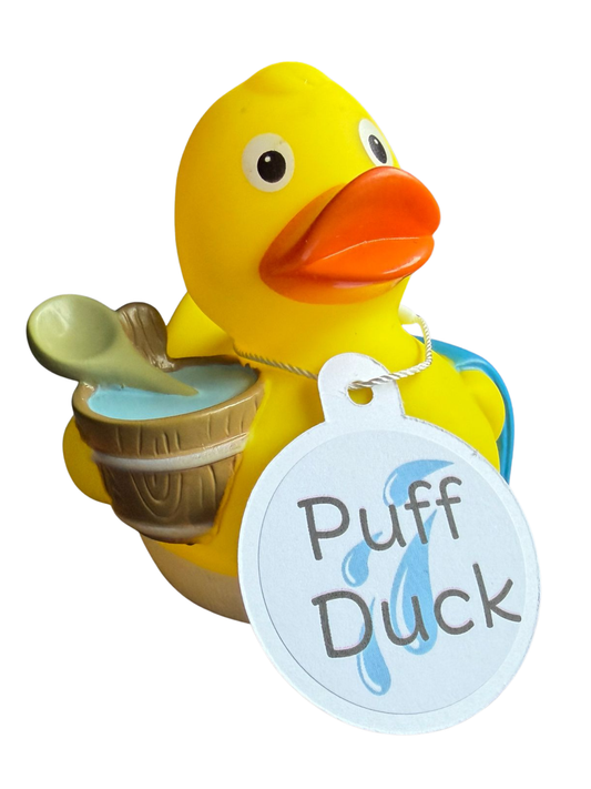 Gele saunabadeend met oranje snavel, houten wateremmer met scheplepel en een lichtblauwe hangtag met de tekst ‘Puff Duck’.