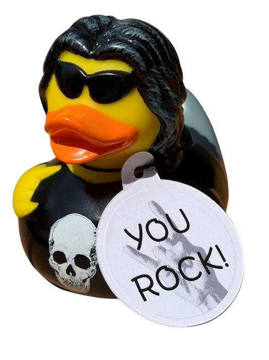 Gele rockerbadeend met zwart haar, zonnebril, zwart shirt met schedel en een hangtag met de tekst ‘You Rock!’.