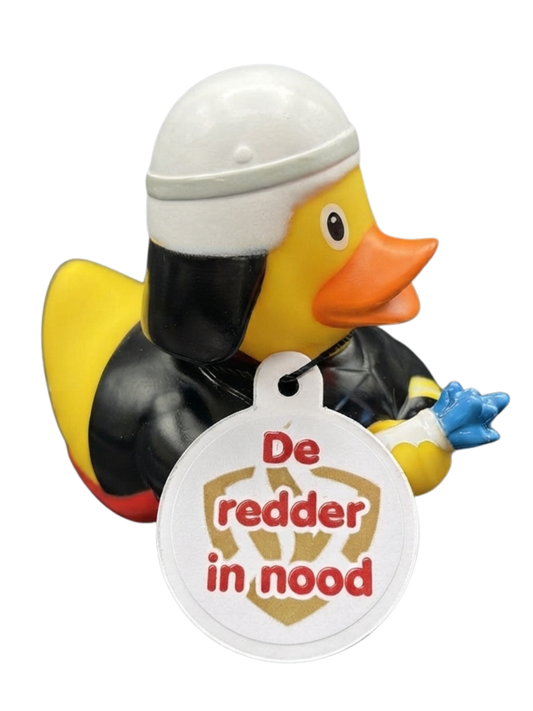 Gele brandweerbadeend met witte helm, zwart uniform en een hangtag met de tekst ‘De redder in nood’.”