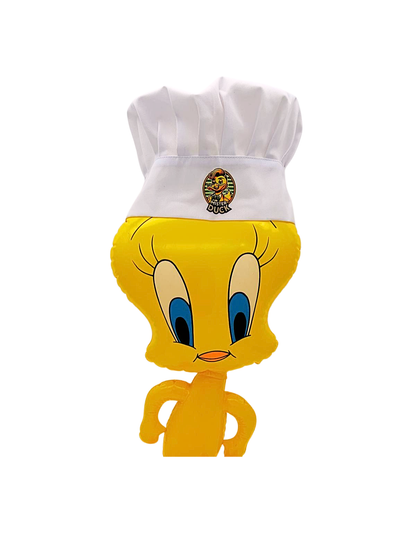 Witte koksmuts met Mister Duck-logo op het hoofd van een gele Tweety-figuur, van voren gezien.