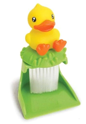 Toetsenbordborstel met witte borstelharen, een gele eend met oranje snavel en pootjes bovenop en een groen blik.